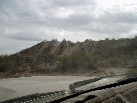 1996 Ford Bronco - Off-road vehicles navigating a challenging trail on a dusty, arid hillside.