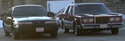 1989 Lincoln Town Car - A maroon 1989 Lincoln Town Car is parked next to a black vehicle, both facing forward.