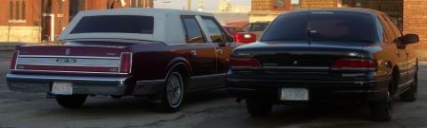 1989 Lincoln Town Car - Rear view of a maroon 1989 Lincoln Town Car next to a black sedan.
