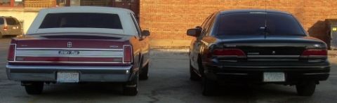 1989 Lincoln Town Car - The rear of a maroon Lincoln Town Car is parked next to a black sedan, both facing away from the camera.