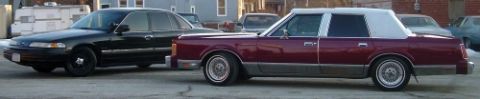 1989 Lincoln Town Car - A maroon 1989 Lincoln Town Car is parked next to a black sedan.