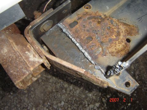 1993 Ford Bronco - Close-up of a rusted metal bracket showing recent welding work.