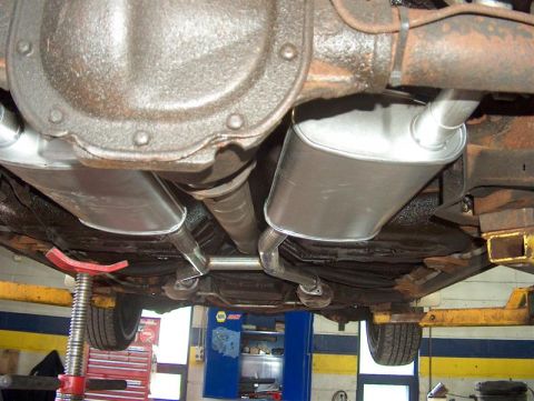 1990 Ford LTD Crown Victoria - New mufflers and exhaust pipes installed on the underside of a vehicle.