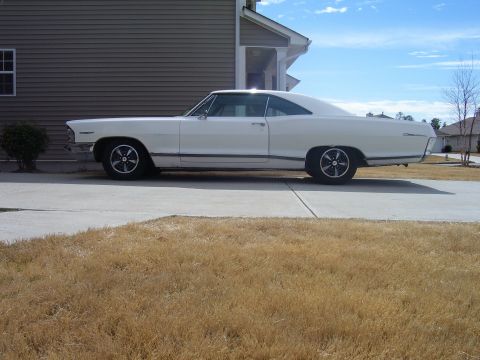 1965 Pontiac Catalina - Side view of a white 1965 Pontiac Catalina coupe parked in front of a house.