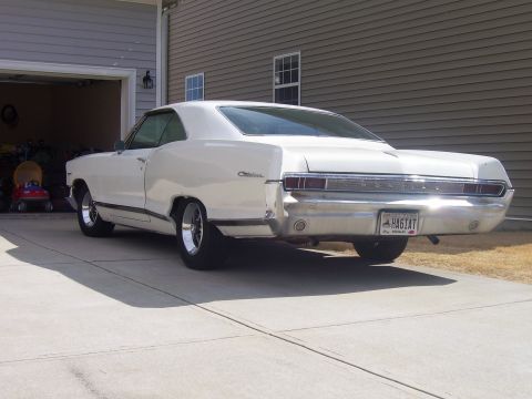 1965 Pontiac Catalina - The rear of a white 1965 Pontiac Catalina coupe is visible, parked in front of a garage.