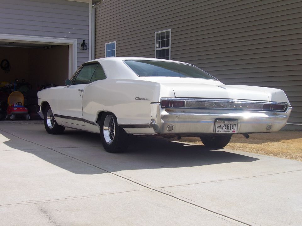 White 1965 Pontiac Catalina coupe parked in driveway, rear view