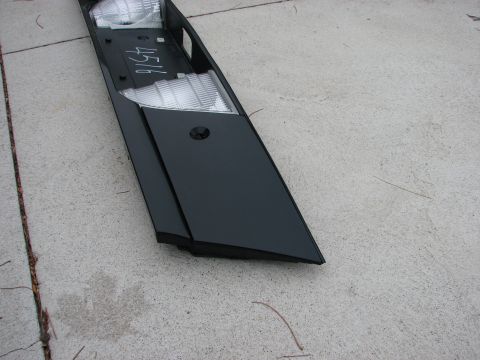 2003 Ford Crown Victoria - A black automotive trim piece with integrated clear lights is shown on a concrete surface.