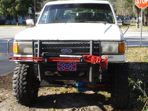 1989 Ford Bronco - This 1989 Ford Bronco features a Hi-Lift jack and a Confederate flag plate on its front bumper.