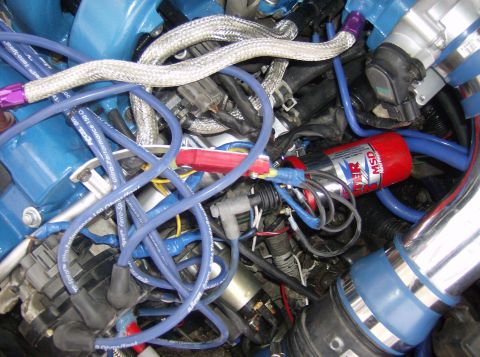1996 Ford Probe - Close-up view of an engine bay aftermarket performance parts like spark plug wires and an ignition coil.
