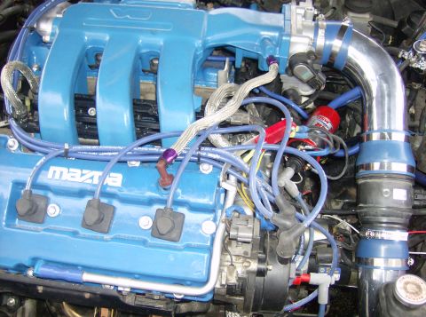 1996 Ford Probe - Close-up view of a modified engine bay, showing custom blue painted components and aftermarket piping.