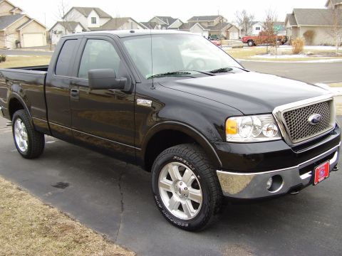 2007 Ford F-150 - This black Ford F-150 pickup truck is shown from a three-quarter front angle on a paved driveway.