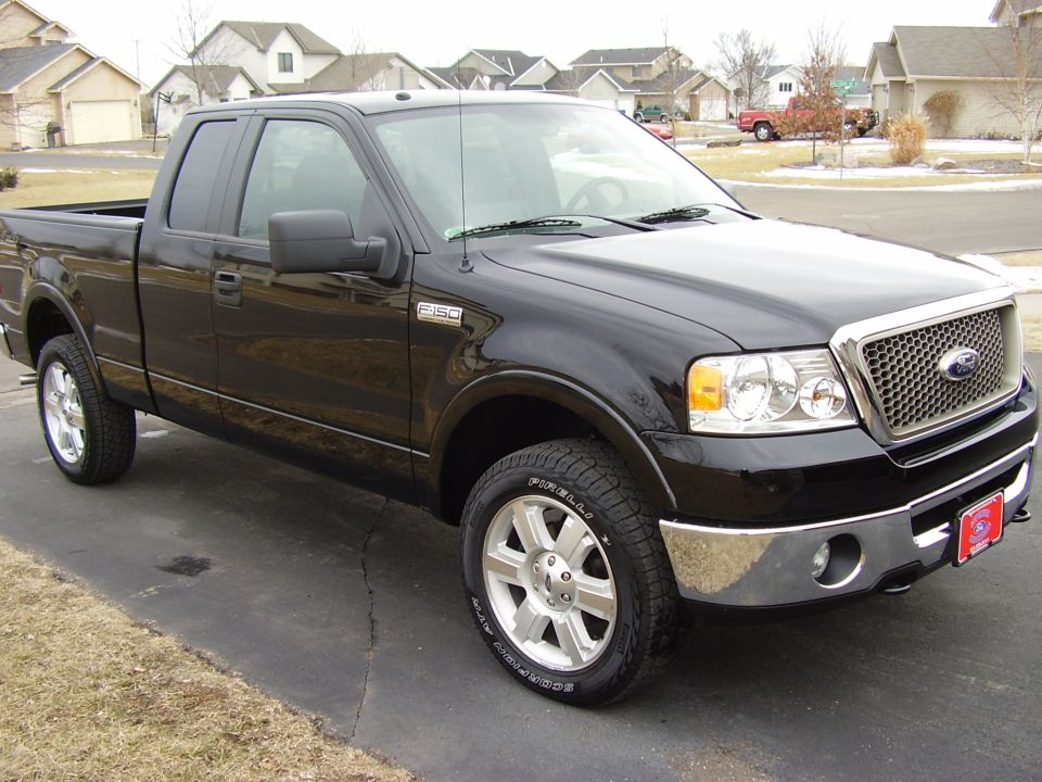 Black Ford F-150 pickup, front 3/4 view on driveway