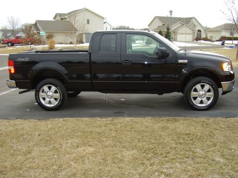 2007 Ford F-150 - This black 2007 Ford F-150 crew cab pickup truck is shown from the side.