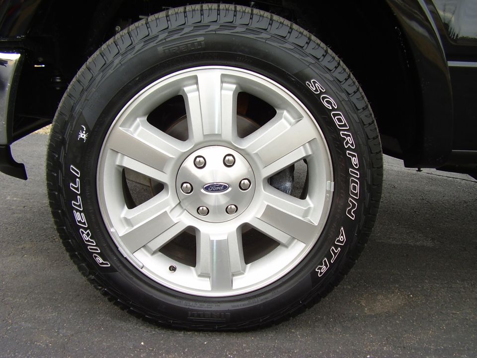 Silver 7-spoke Ford wheel with Pirelli Scorpion ATR white-letter tire