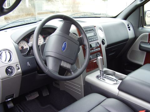 2007 Ford F-150 - The interior of a 2007 Ford F-150 features a detailed dashboard with clear gauges and a wood-grain trim on the center console.