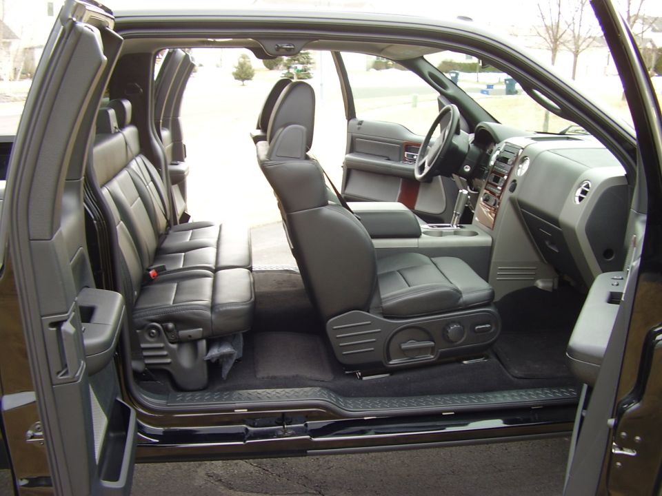 Gray leather interior of extended-cab pickup viewed through open passenger-side doors