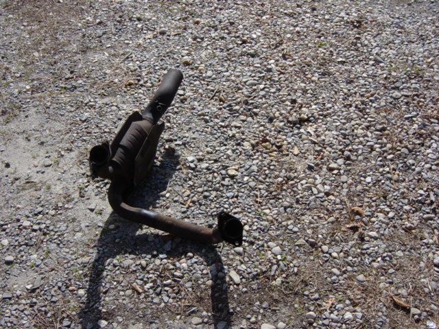 Exhaust pipe and catalytic converter lying on gravel
