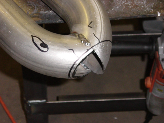 Two mandrel-bent exhaust tubes tack-welded at a Y-merge with marker cut lines