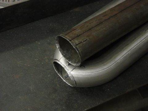 1991 Ford Bronco - Close-up of two exhaust pipes, one showing preparation for modification.
