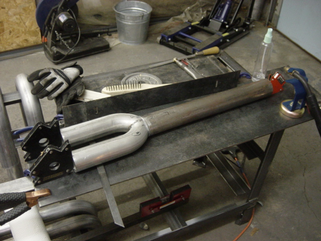 Exhaust pipe assembly with two inlets and one outlet, held by magnetic clamps on a workbench