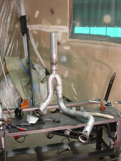 1991 Ford Bronco - Custom exhaust system components laid out on a work surface, ready for installation.