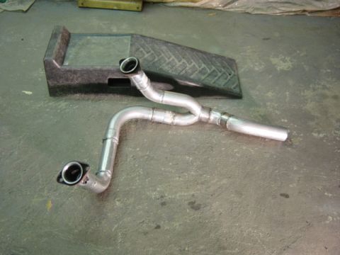 1991 Ford Bronco - A custom exhaust Y-pipe with dual outlets is shown on a concrete floor next to a ramp.
