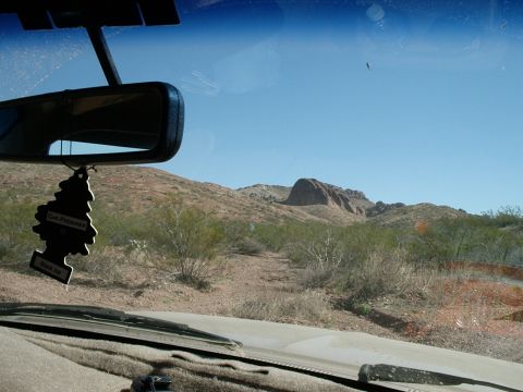 1996 Ford Bronco - The view from inside a vehicle shows a desert landscape with scrub brush and rock formations under a clear blue sky.