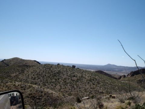 1996 Ford Bronco - View from a vehicle overlooking a vast desert landscape with rolling hills and distant mountains.