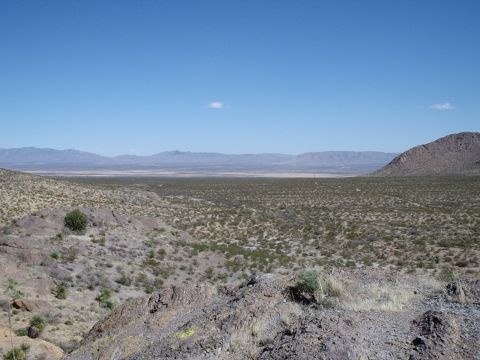 1996 Ford Bronco - Expansive desert terrain with sparse vegetation and distant mountains.