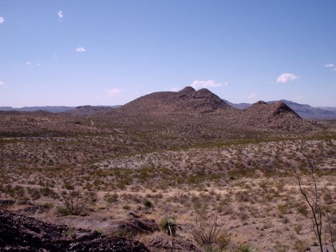 1996 Ford Bronco - A wide view of a desert landscape with mountains in the background and sparse vegetation in the foreground.