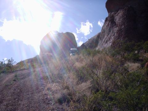 1996 Ford Bronco - SUV parked on a remote, rocky trail with sun glare.