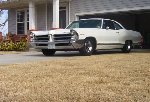 1965 Pontiac Catalina - A white 1965 Pontiac Catalina is parked in a driveway in front of a house.