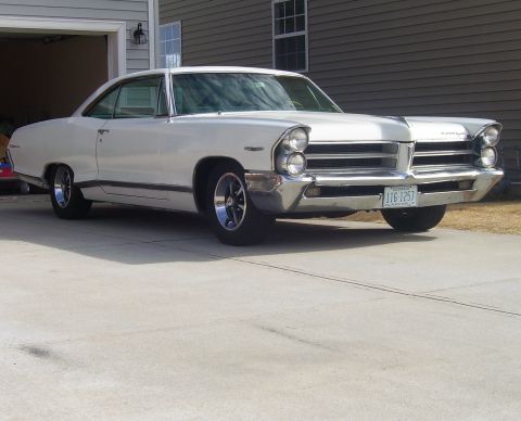 1965 Pontiac Catalina - A white 1965 Pontiac Catalina is viewed from the front three-quarter angle in front of a garage.