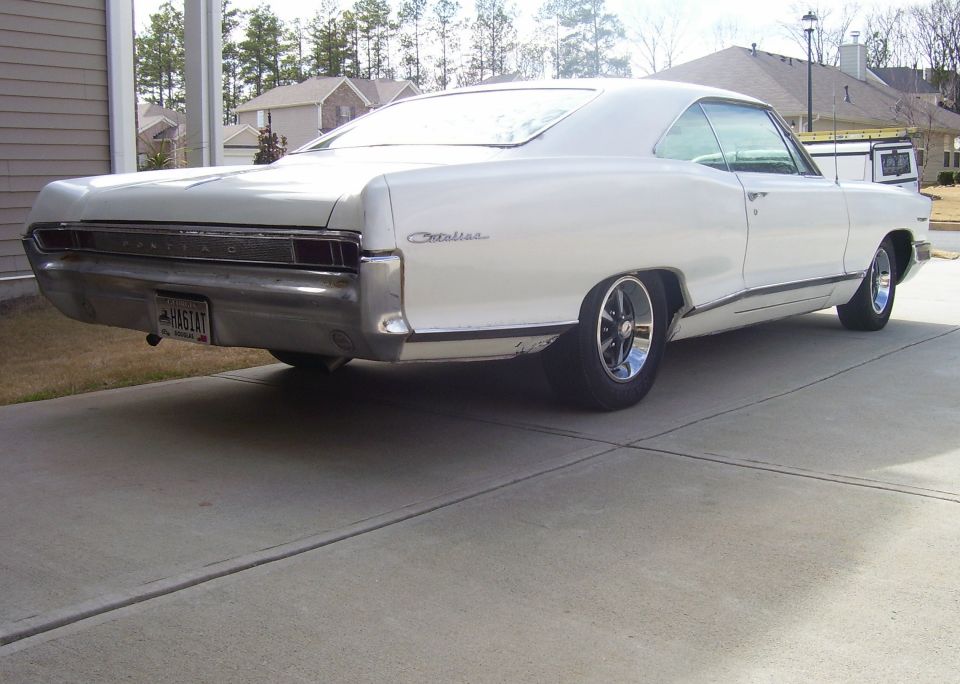 White Pontiac Catalina hardtop from the rear quarter with chrome five-spoke wheels