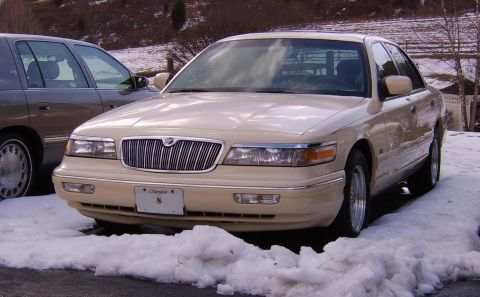 1996 Mercury Grand Marquis - A Mercury Grand Marquis sits in the snow, its grille and headlights clearly visible.