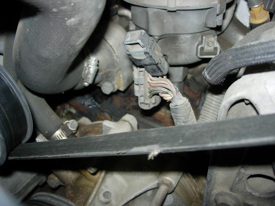 Close-up of engine wiring harness and distributor with frayed wires
