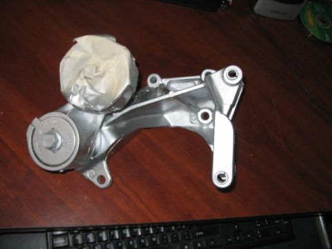 1991 Ford Bronco - A metallic engine component, partially covered with tape, is displayed on a desk.