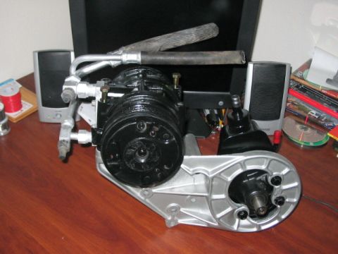 1991 Ford Bronco - Air conditioning compressor assembly shown on a wooden desk with computer speakers in the background.
