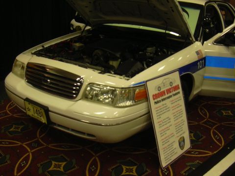 1996 Ford Crown Victoria - 1996 Ford Crown Victoria police interceptor on display with hood open, showing the engine compartment.