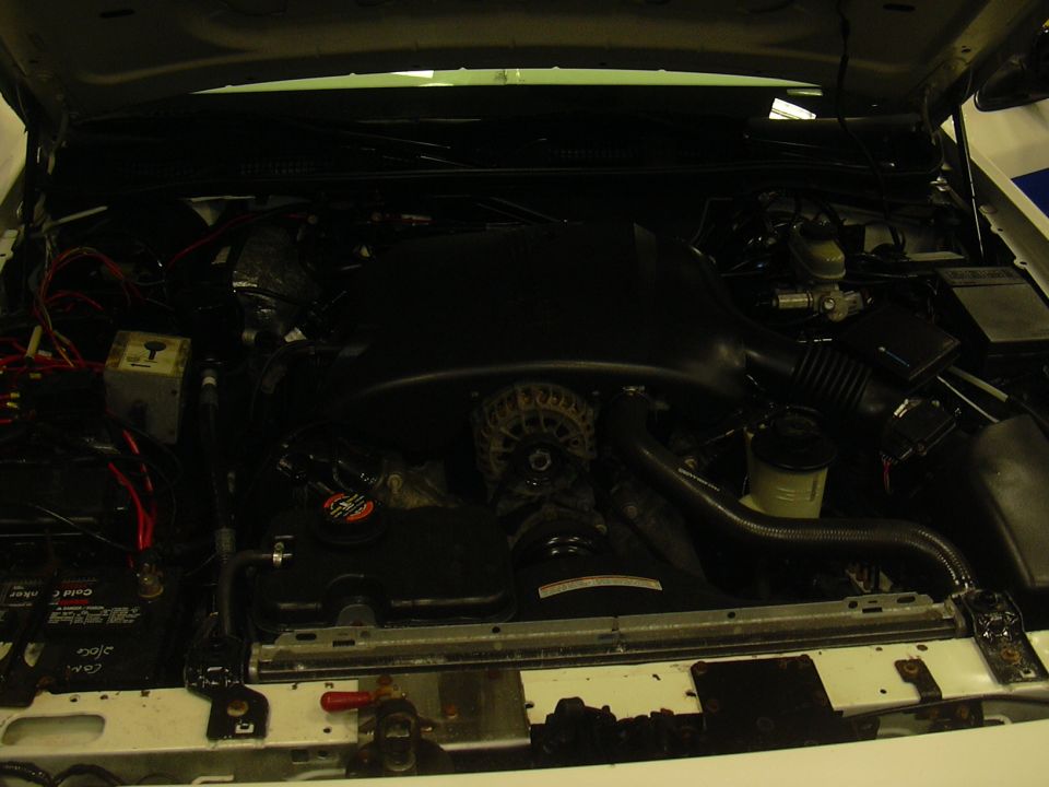 1996 Ford Crown Victoria engine bay with hood open, showing the engine, alternator, battery, and various hoses and wires