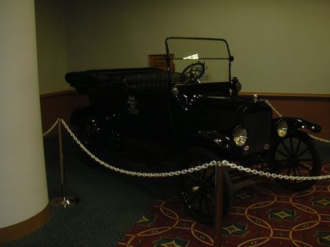 1996 Ford Crown Victoria - A vintage Ford Model T is displayed indoors, separated from viewers by a white chain barrier.