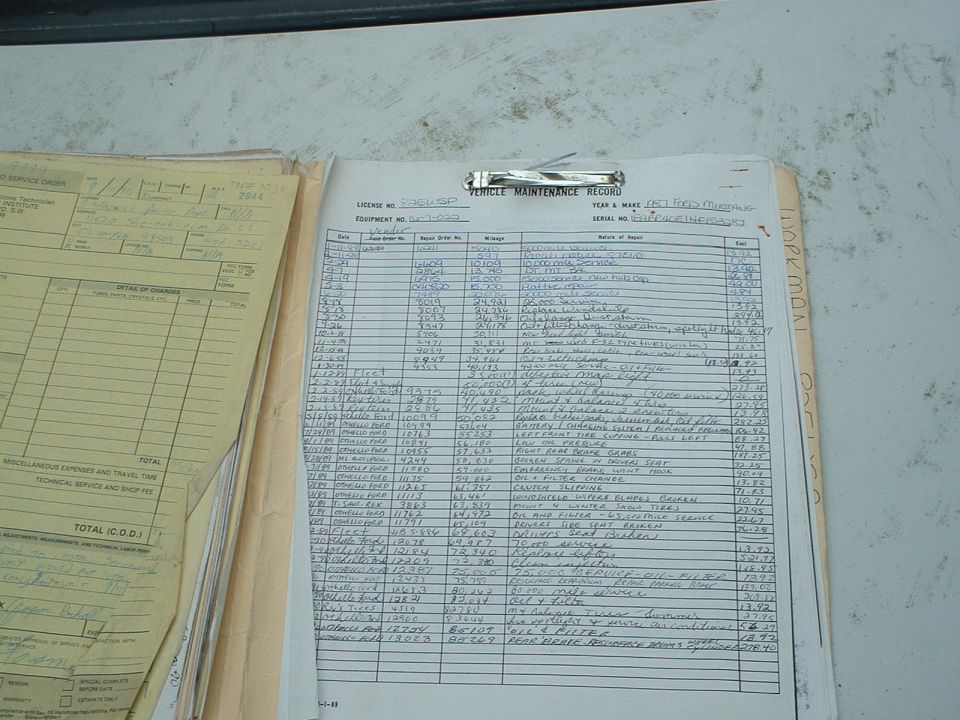 Vehicle maintenance record document with handwritten entries and printed text