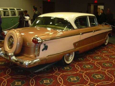 1996 Ford Crown Victoria - A classic two-tone sedan with a continental kit is displayed indoors.