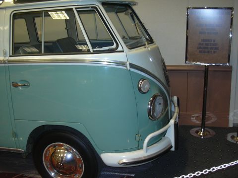 1996 Ford Crown Victoria - A two-tone teal and white Volkswagen Type 2 Bus is displayed at an auto show, with a sign providing details about its provenance.
