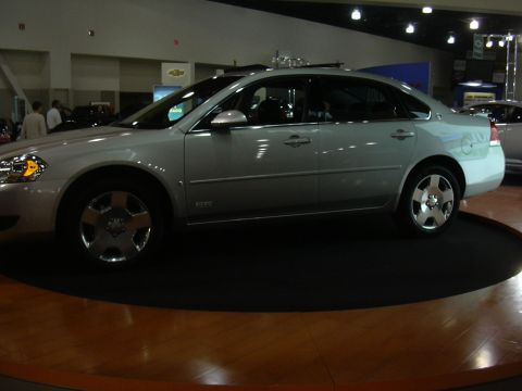1996 Ford Crown Victoria - A silver sedan with SS badging is displayed indoors on a rotating platform.