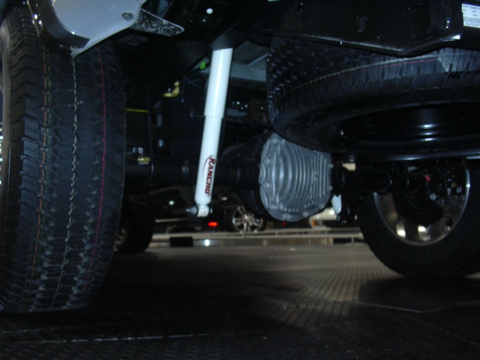 Underbody view of a vehicle's spare tire, differential, and Rancho shock absorber