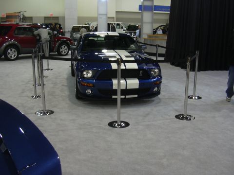 1996 Ford Crown Victoria - A blue Ford Mustang Shelby GT500 is displayed at an indoor event, cordoned off with stanchions.