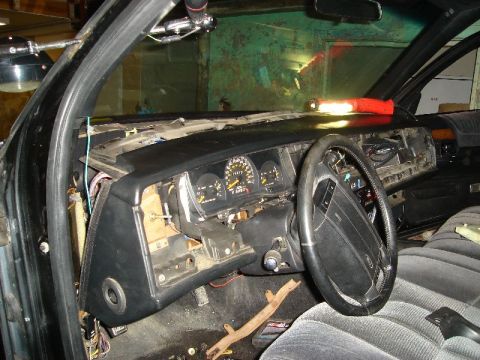 1992 Ford Crown Victoria - The interior of a vehicle shows a disassembled dashboard with exposed wiring and a steering wheel, indicating ongoing work.