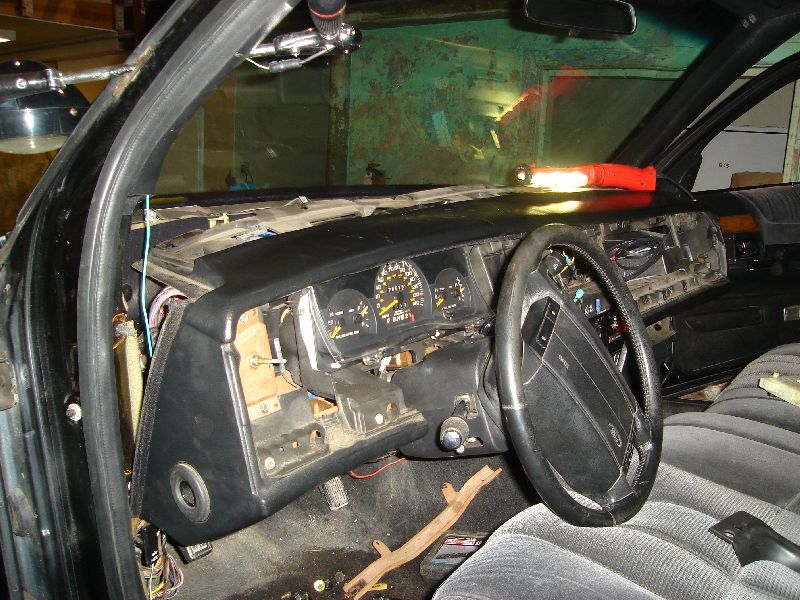 Interior dashboard with exposed wiring and a steering wheel