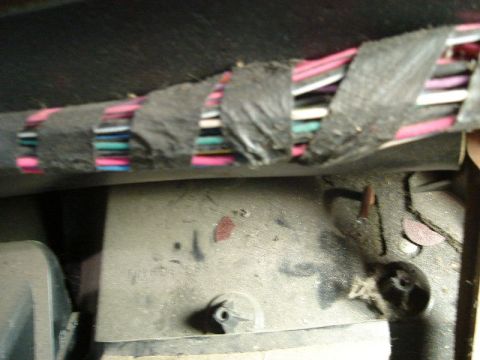 1992 Ford Crown Victoria - A close-up view shows a bundle of wires secured with black tape, typical of a vehicle's interior wiring.